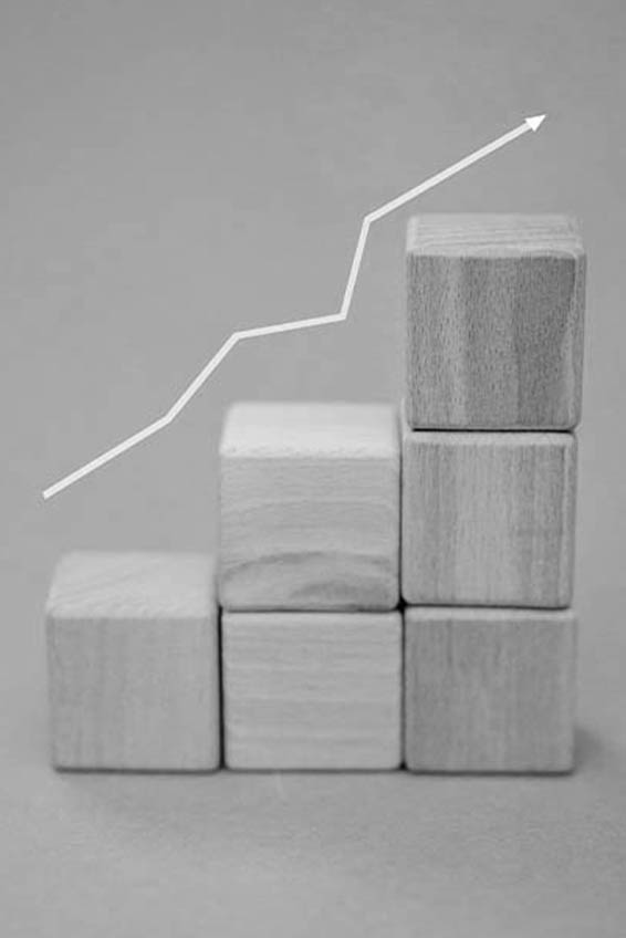 Növekedést mutató grafikon fakockákon, ami a weboldal és a hirdetések összehangolását, valamint az olcsóbb kattintási költségeket eredményező ökoszisztémát mutatja.