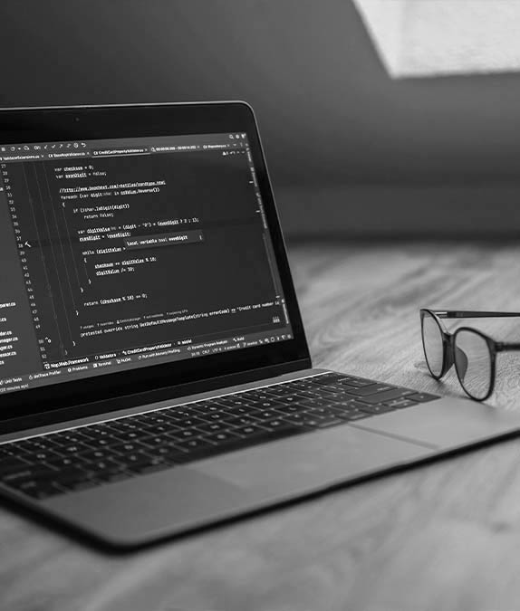 Kódolás egy modern laptopon, ami a gyors, biztonságos és kompromisszummentes céges weboldal készítést és egyedi fejlesztést jeleníti meg vállalkozások számára.