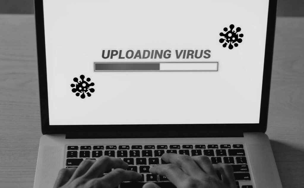 Vírusfeltöltést mutató laptop képernyő, amely a karbantartás hiányának veszélyeire és a weboldalak páncélterem szintű vírusvédelmére, valamint tűzfalára hívja fel a figyelmet.